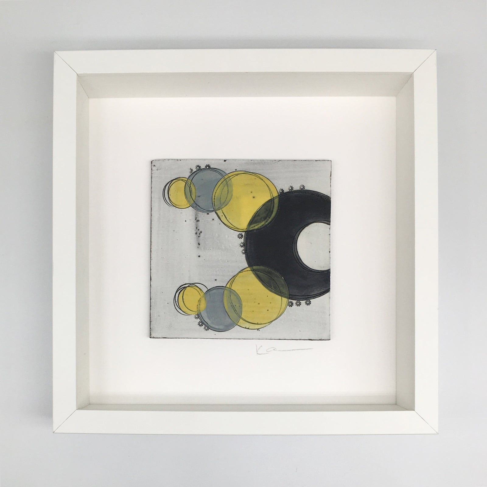 A framed small wall plaque - black crescents and vibrant yellow spots