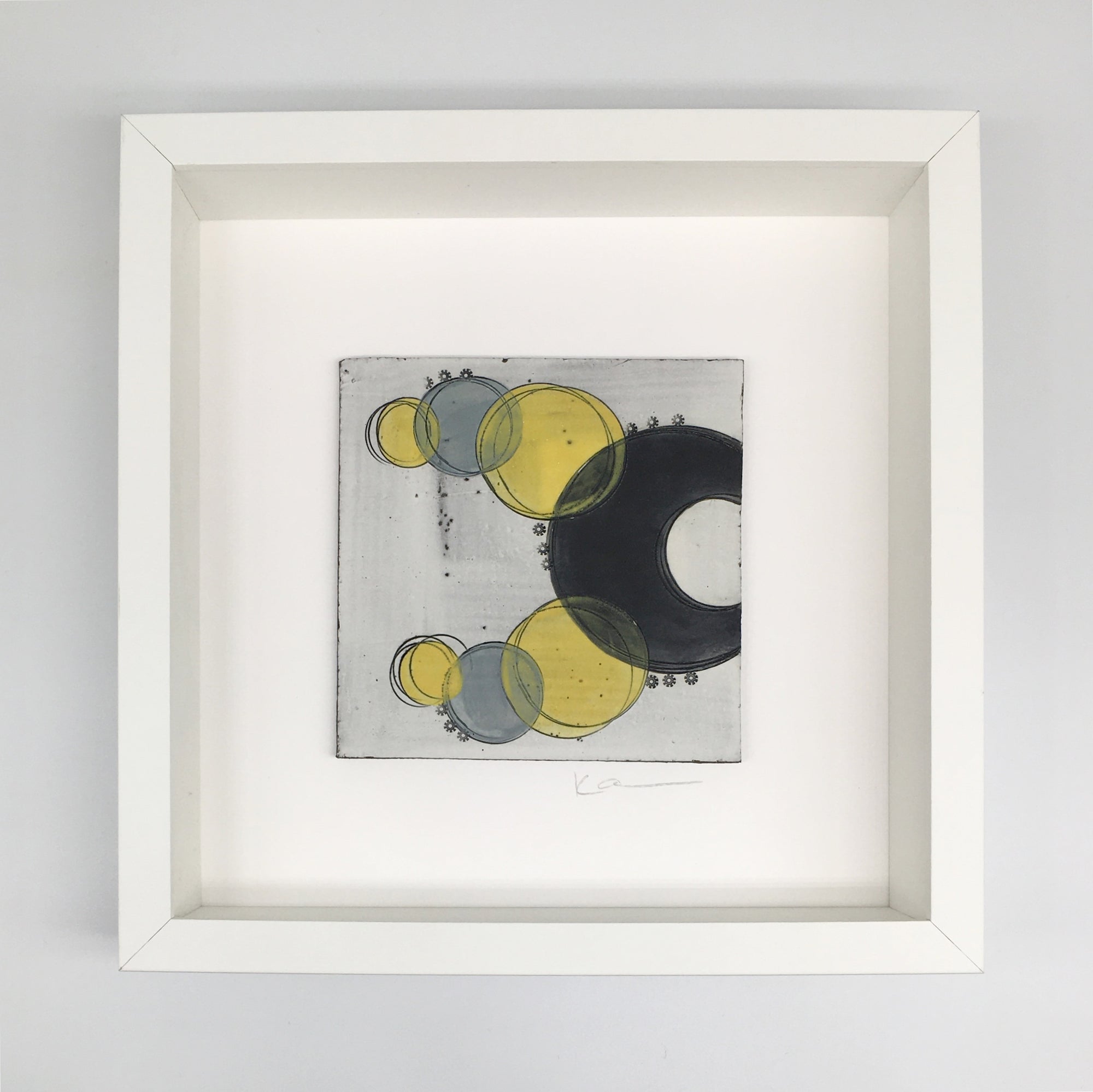 A framed small wall plaque - black crescents and vibrant yellow spots